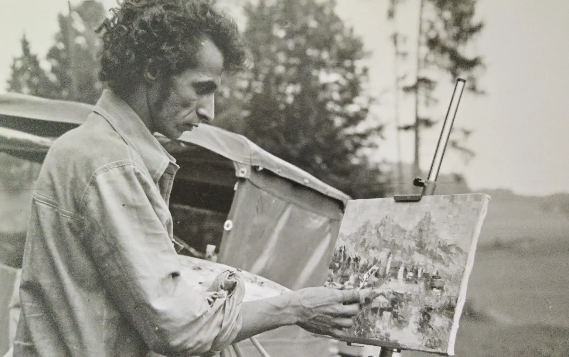 The artist painting at his easel outdoors